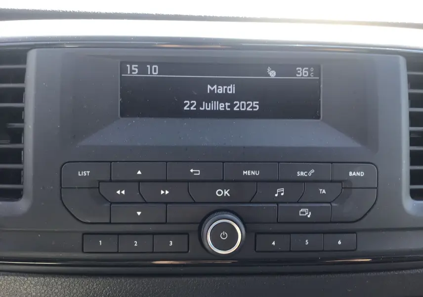 Affichage central de la radio de l'Opel Vivaro blanc 2023, avec écran digital indiquant la date et la température.