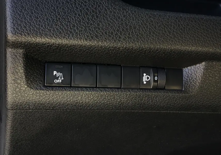 Boutons de commande du tableau de bord noir de l'Opel Vivaro blanc, avec réglage des phares et désactivation du radar de recul.