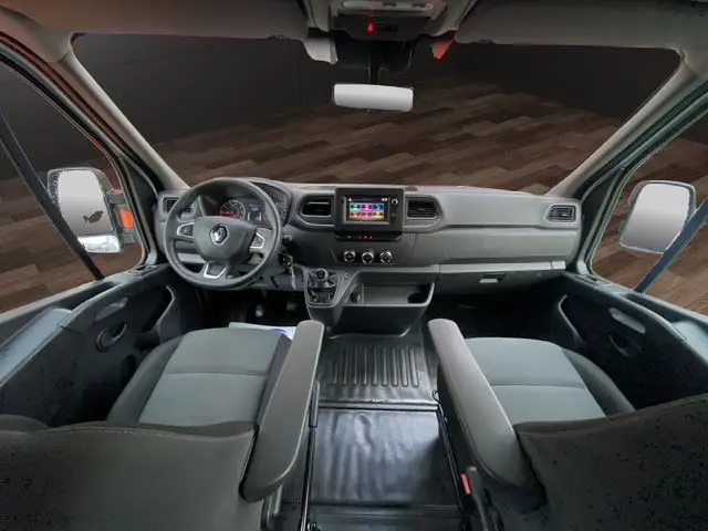 Vue intérieure avant du Renault Master blanc, montrant le tableau de bord avec écran GPS et sièges tissu noir.