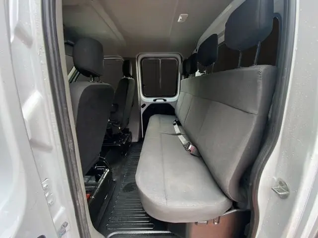 Vue intérieure côté droit du Renault Master blanc, montrant la banquette arrière 3 places en tissu gris foncé.