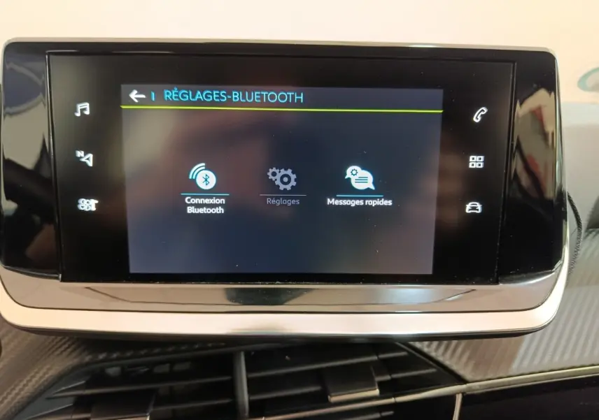 Écran tactile central de la Peugeot 208 électrique Active Business R affichant les réglages Bluetooth, intérieur noir.