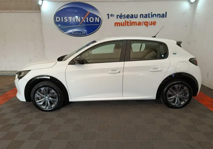 Profil côté gauche d'une Peugeot 208 électrique Active Business R blanche, avec jantes gris foncé et rétroviseurs noirs.