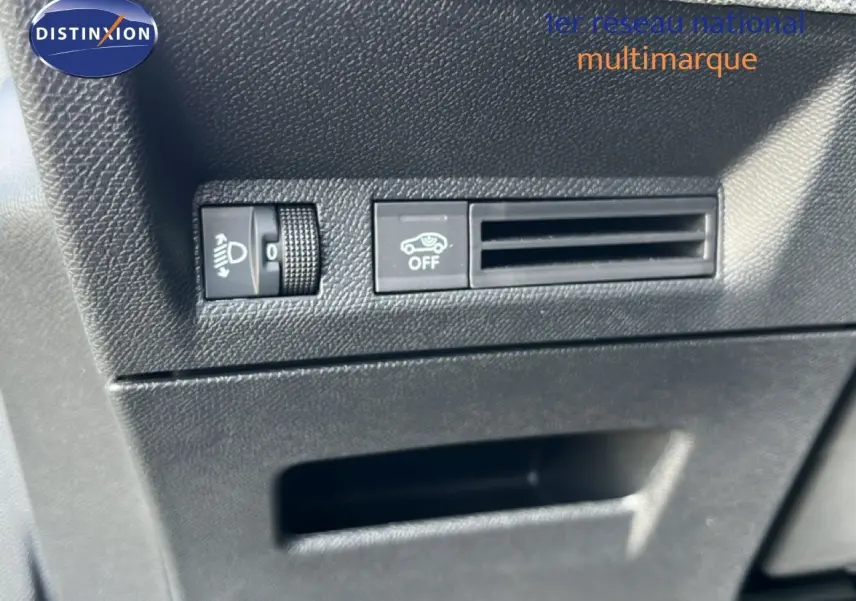 Détail intérieur montrant les commandes de réglage des phares et la ventilation sur Peugeot 5008 gris Artense 2025.