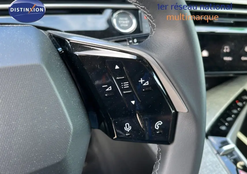 Gros plan sur les commandes au volant à droite du Peugeot 5008 gris Artense, avec touches de volume et téléphone.