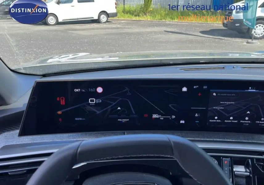 Vue intérieure du tableau de bord numérique du Peugeot 5008 gris Artense, affichant la navigation et les informations de conduite.