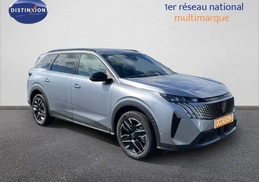 Peugeot 5008 Hybrid gris Artense métal en 3/4 avant droit, avec calandre distinctive et jantes noires bicolores.