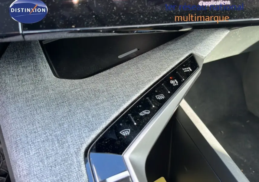 Vue rapprochée de la console centrale grise tissu du Peugeot 5008 Hybrid 2025, avec commandes tactiles et finition moderne.