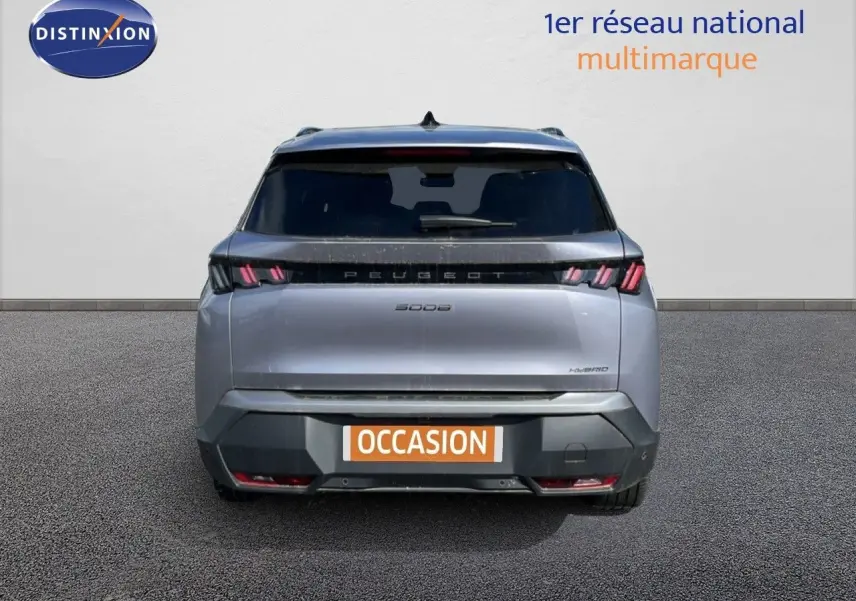 Vue arrière d'un Peugeot 5008 hybride gris Artense métal 2025 avec feux LED et plaque d'occasion visible.