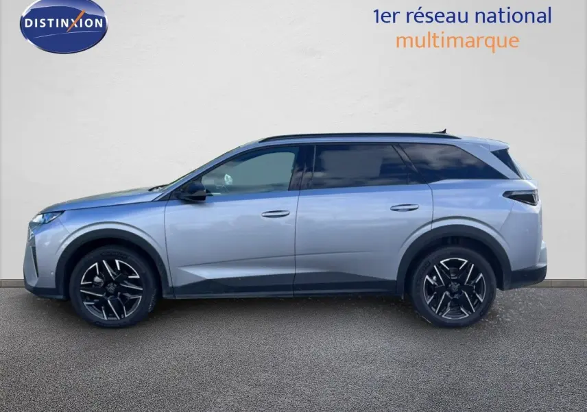 Profil droit du Peugeot 5008 Hybrid gris Artense métallisé, avec jantes noires et toit panoramique visible.