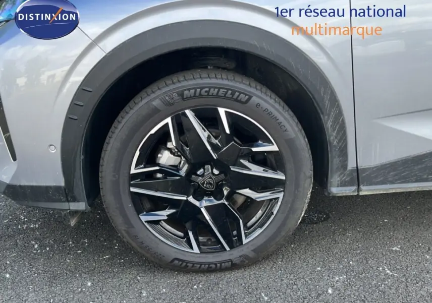 Gros plan sur la roue avant droite d’un Peugeot 5008 gris Artense métal avec jante noire et argentée au design moderne.
