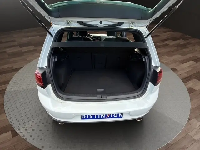 Vue arrière ouverte d'une Volkswagen Golf GTI Performance blanche de 2019, coffre spacieux visible avec banquette rabattable.