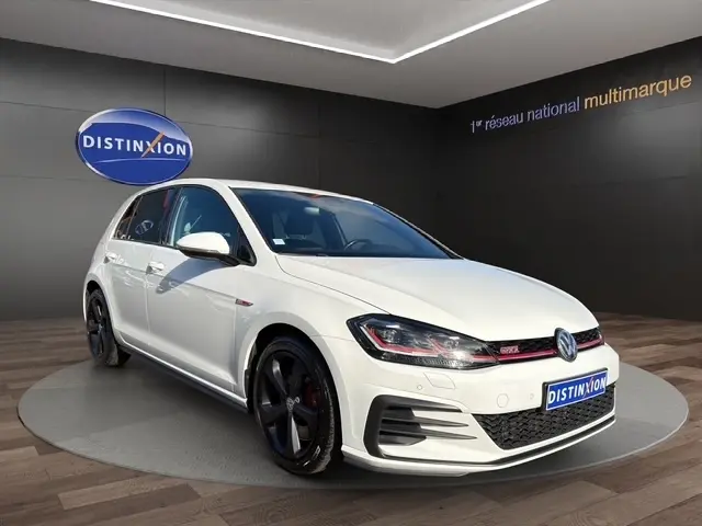 Volkswagen Golf GTI Performance blanche vue 3/4 avant droit avec jantes noires et détails rouges.