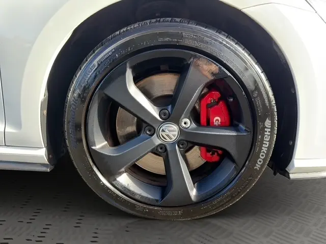 Gros plan sur la roue avant droite d’une Volkswagen Golf GTI Performance blanche, avec étrier de frein rouge visible.