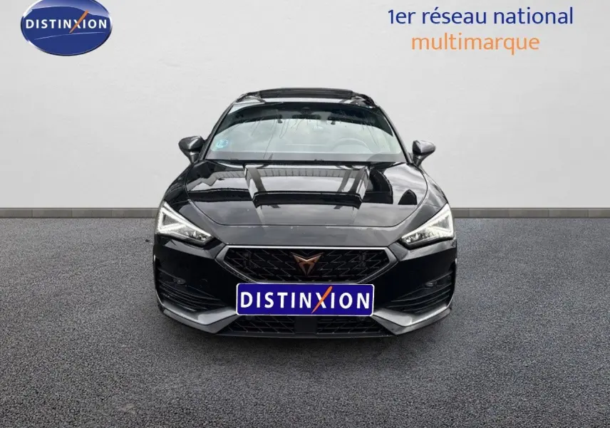 Vue frontale d'une CUPRA LEON ST noire Midnight Metal avec calandre distinctive et phares LED allumés.