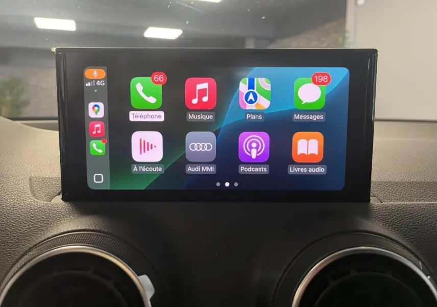 Écran tactile central de l'Audi Q2 2022 affichant l'interface Apple CarPlay avec icônes colorées, vue intérieure frontale.