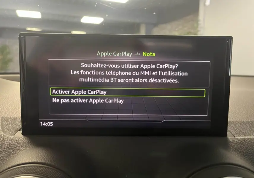 Écran central de l'Audi Q2 2022 affichant le menu d'activation d'Apple CarPlay dans l'habitacle noir.
