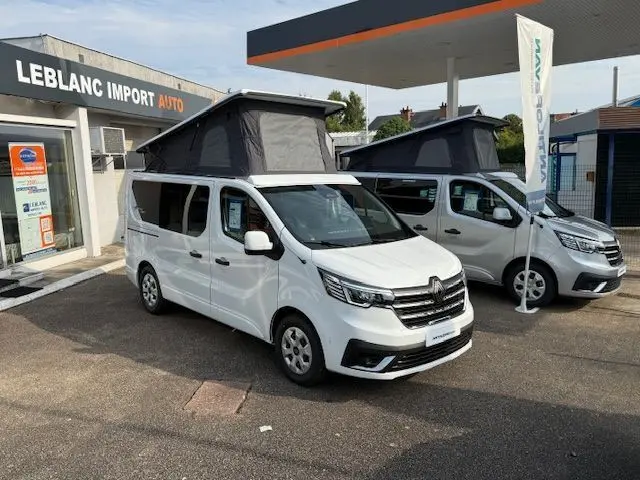 Vue 3/4 avant gauche du Renault Trafic Fourgon blanc glacier avec toit relevable noir ouvert sur parking concession.