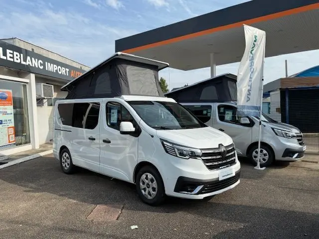 Vue 3/4 avant droit d'un Renault Trafic Fourgon blanc glacier avec toit relevable gris et vitres latérales teintées.