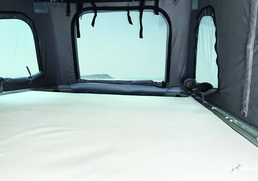 Vue intérieure du couchage haut sous toit relevable du Renault Trafic Fourgon blanc glacier avec toile grise Antilope Van