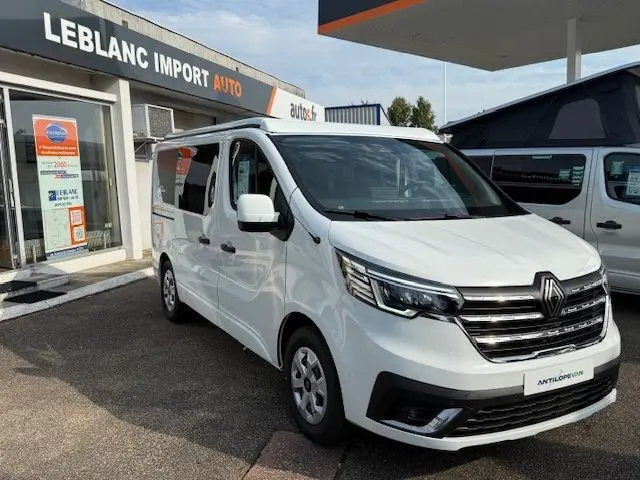 Renault Trafic Fourgon blanc glacier vu en 3/4 avant droit, avec calandre chromée et toit relevable visible.