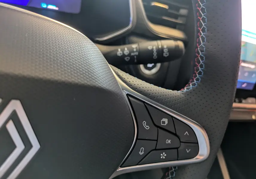 Gros plan sur le volant cuir perforé noir avec surpiqûres tricolores du Renault Symbioz E-Tech hybride 2025.