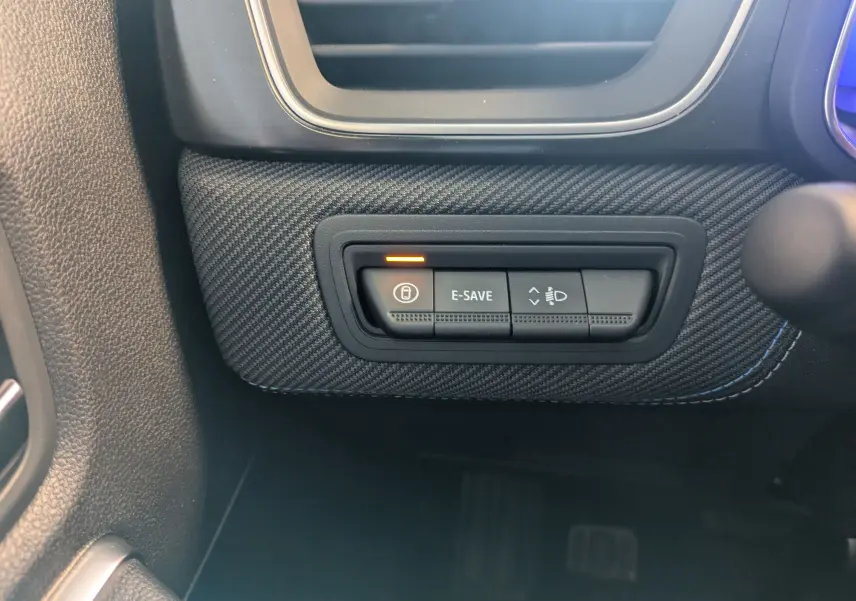 Gros plan sur les commandes E-SAVE et réglage des phares dans l'habitacle noir du Renault SYMBIOZ E-Tech 2025.