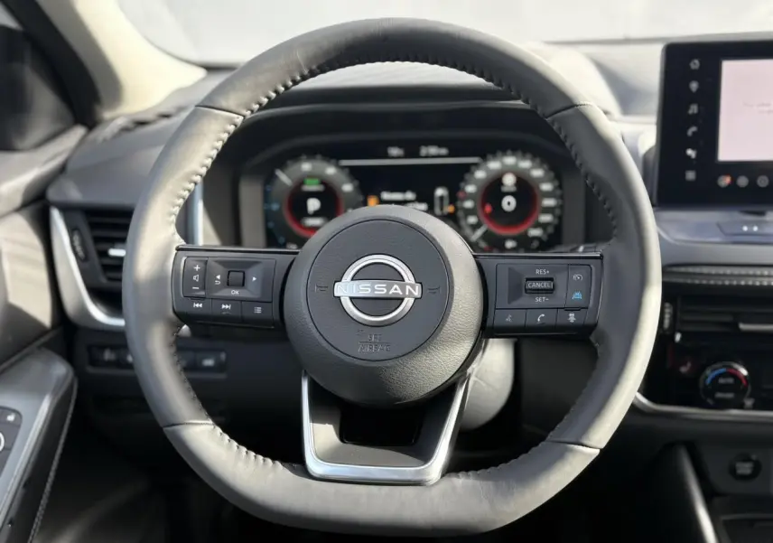 Vue frontale du volant cuir noir du Nissan Qashqai III e-Power 2025 avec commandes intégrées et tableau de bord numérique.