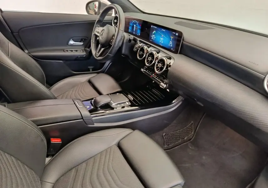 Vue intérieure côté conducteur de la Mercedes Classe A 180 Business Line 2020 avec tableau de bord numérique et volant cuir multifonctions.
