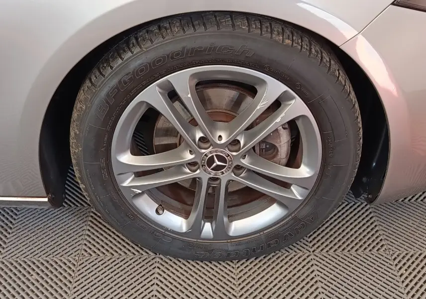 Gros plan sur la roue avant droite gris clair d'une Mercedes Classe A avec jante alliage à cinq branches doubles.