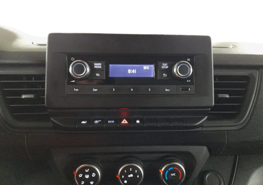 Vue rapprochée du tableau de bord du Renault Trafic Fourgon 2024, avec commandes radio et climatisation visibles.