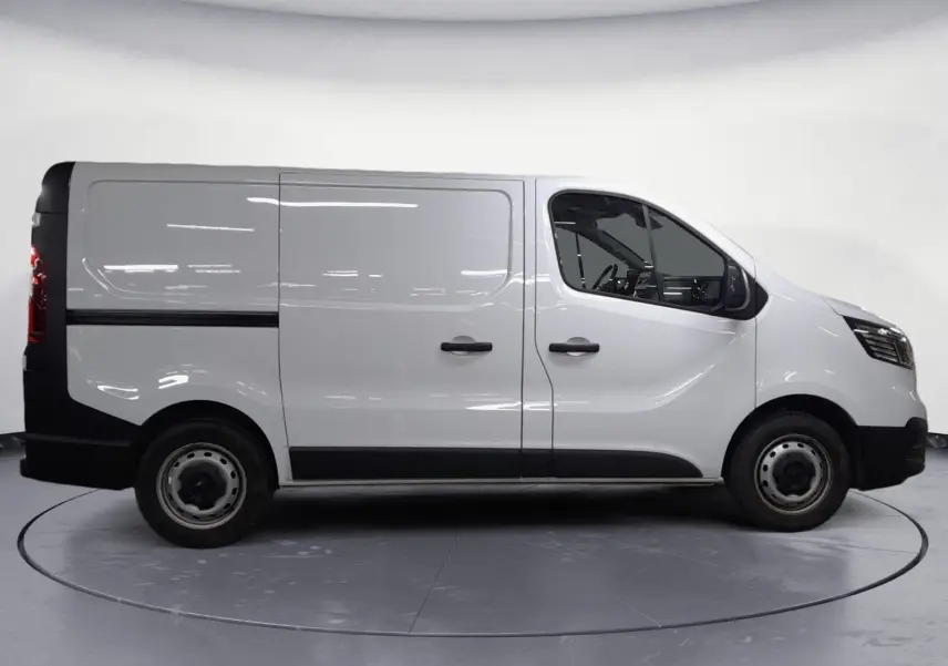 Vue de profil côté gauche du Renault Trafic Fourgon blanc minéral, avec portes latérales et jantes acier noires.