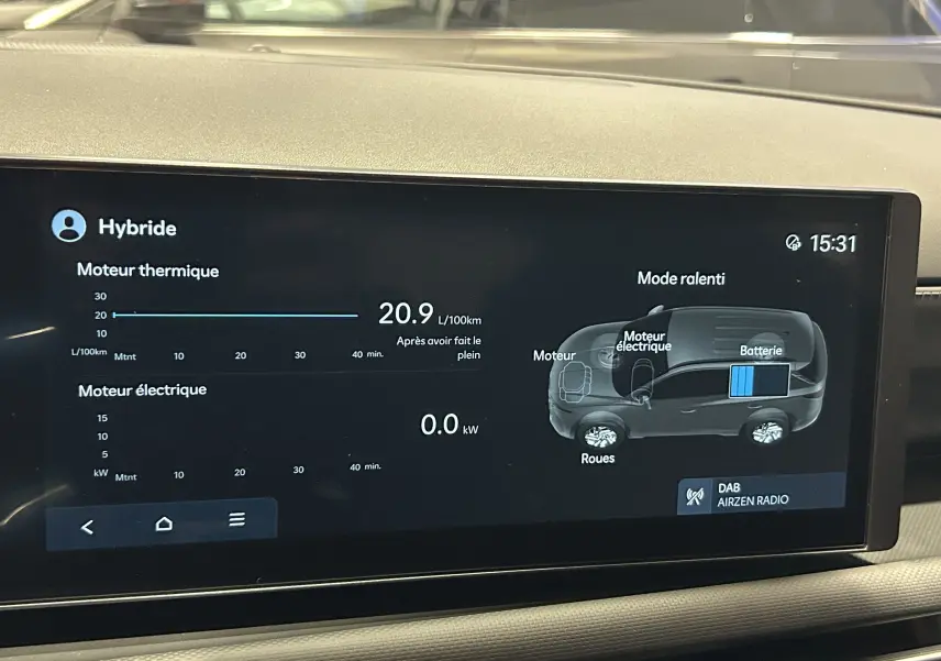 Écran multimédia du Hyundai Tucson hybride 2025 montrant consommation et schéma batterie en mode ralenti.