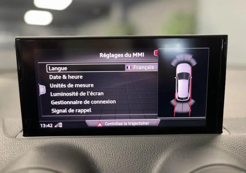 Écran central MMI de l'Audi Q2 noir 2022 affichant les réglages en français avec vue du système de détection de proximité.