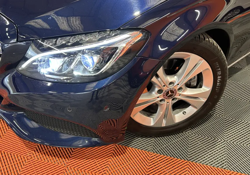 Gros plan sur l'avant droit bleu d'une Mercedes Classe C 200d, mettant en valeur le phare LED et la jante alliage.