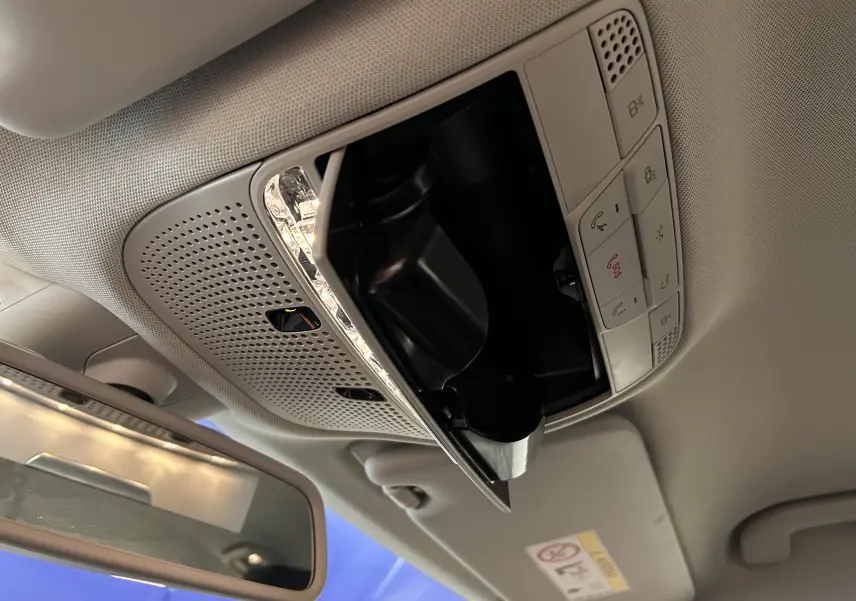 Plafonnier intérieur avec commandes et rangement lunettes ouverts dans une Mercedes Classe C 200d bleu de 2018.