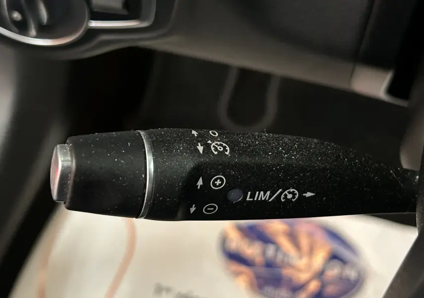 Le levier de régulateur de vitesse et limiteur sur le côté gauche du volant d'une Mercedes Classe C bleue 2018.