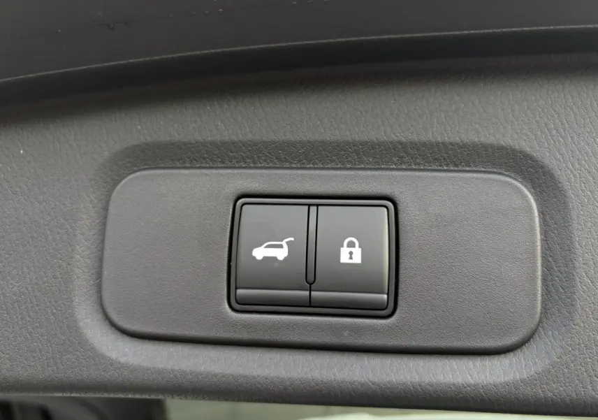 Boutons d'ouverture électrique du hayon et de verrouillage sur panneau intérieur du Nissan Qashqai blanc nacré 2025.