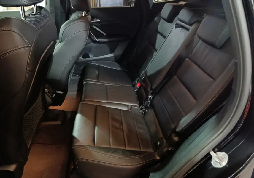 Vue intérieure côté droit montrant la banquette arrière noire en cuir du BMW X1 xDrive23i M Sport 2023.