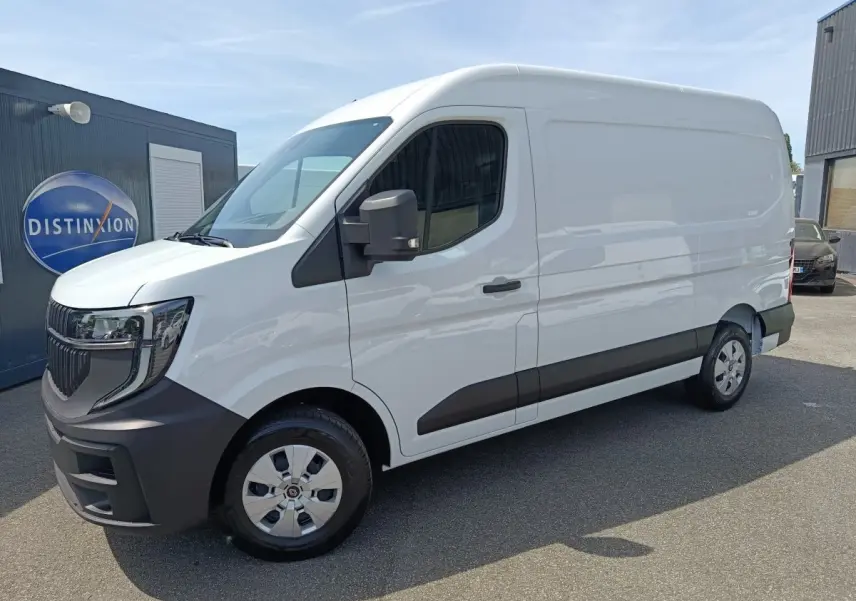 Renault Master blanc en vue 3/4 avant droit, avec pare-chocs et bas de caisse noirs, stationné devant un bâtiment.