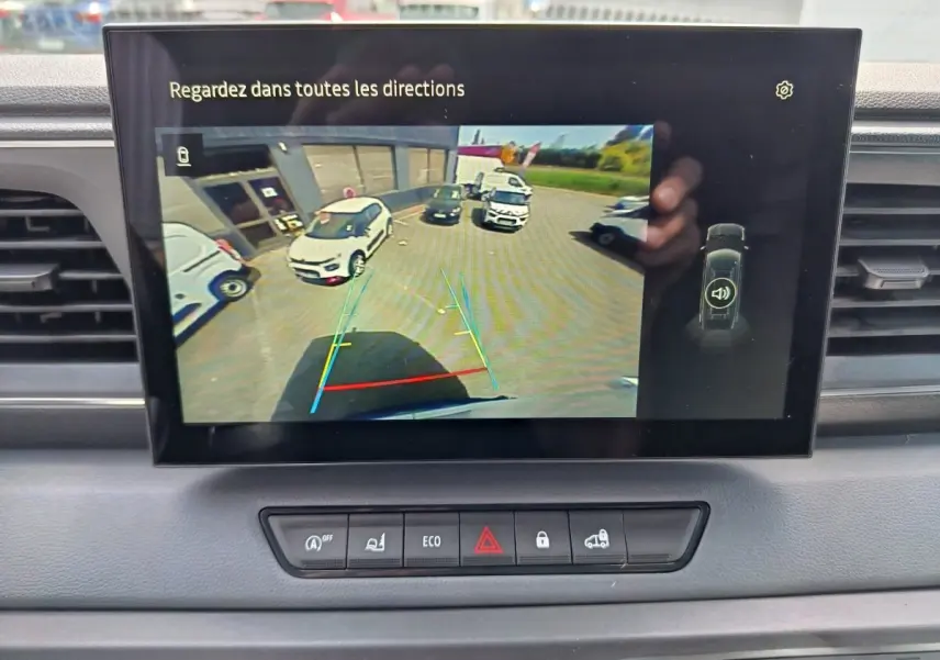 Écran tactile intérieur du Renault Master blanc montrant la caméra de recul avec vue arrière et aides au stationnement.