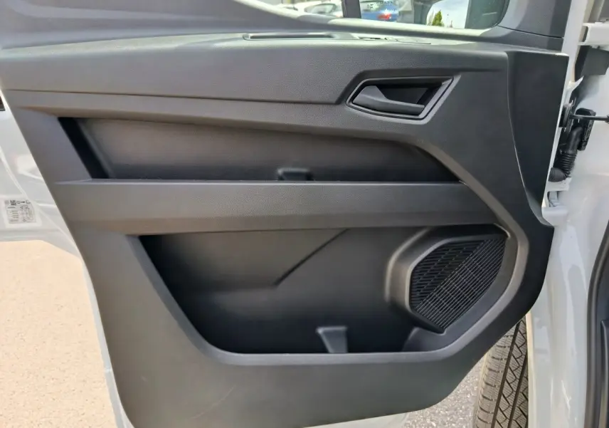 Vue rapprochée de la porte avant droite noire intérieure du Renault Master blanc, avec haut-parleur intégré.
