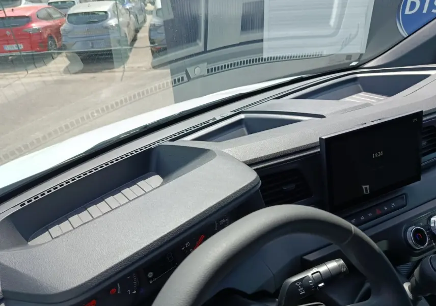 Vue intérieure du tableau de bord et volant du Renault Master blanc, avec écran tactile central et commandes visibles.