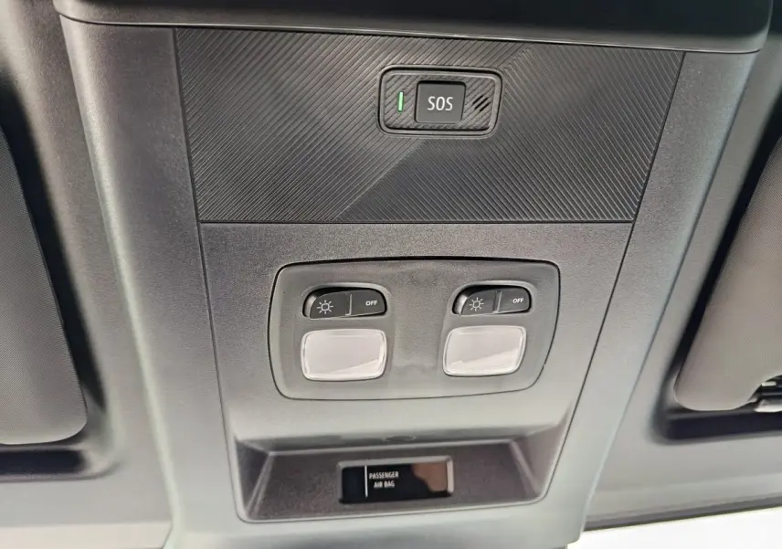 Vue en contre-plongée du plafonnier gris avec bouton SOS et commandes d’éclairage du Renault Master blanc 2025.