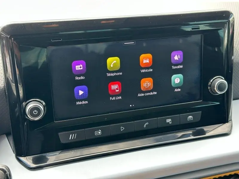 Écran tactile central du tableau de bord du SEAT Arona 2025 avec interface multimédia colorée et commandes physiques en dessous.