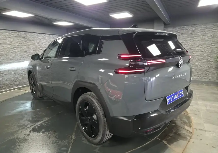 Vue 3/4 arrière droite du Citroën C5 Aircross gris métallisé avec feux arrière LED et jantes noires.