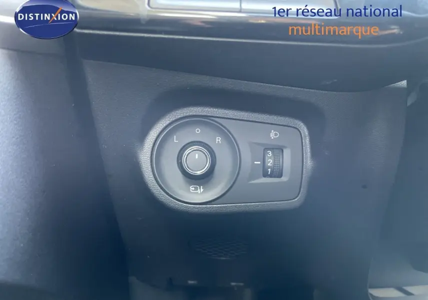 Gros plan sur les commandes de réglage des rétroviseurs et des phares d’un MG3 1.5L Hybrid+ 2024 en intérieur noir.