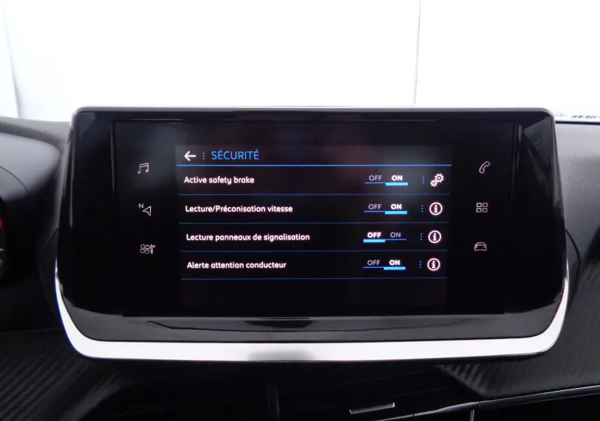 Écran tactile central du tableau de bord de la Peugeot 208 affichant les options de sécurité activées.