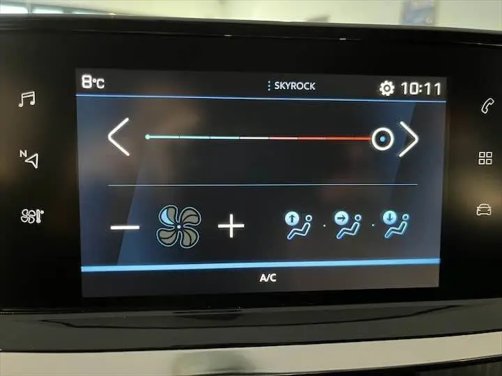 Écran tactile du système de climatisation de la Peugeot 208 rouge Elixir Metal, affichant réglage de la ventilation et température.