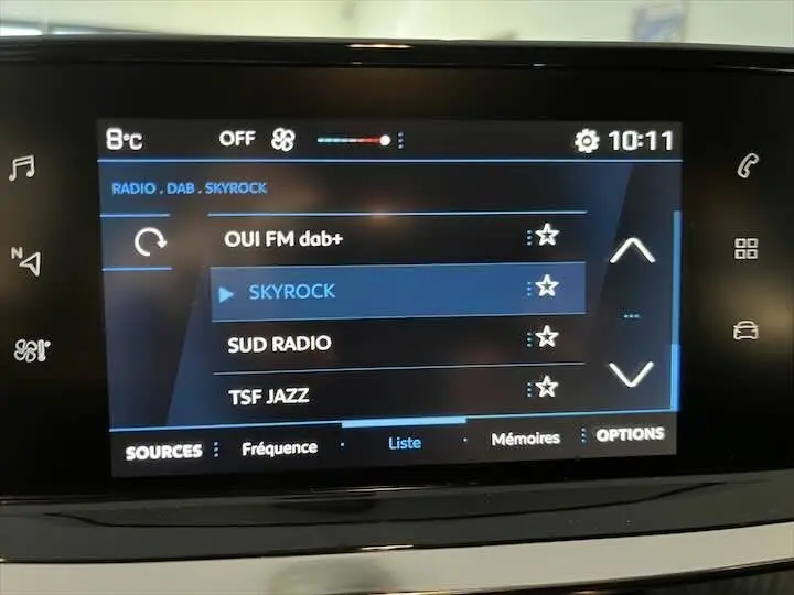 Écran tactile multimédia de la Peugeot 208 rouge Elixir Metal affichant la liste des radios DAB+ avec Skyrock sélectionné