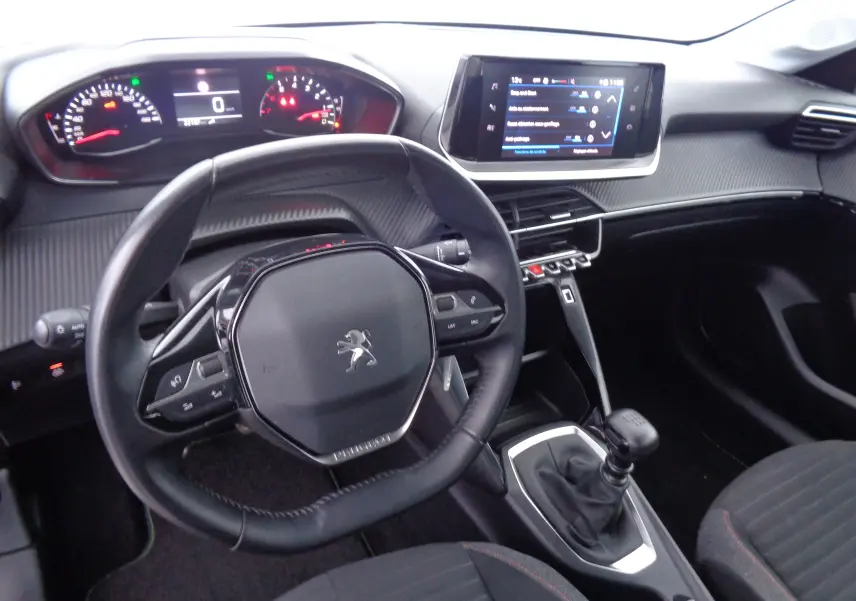Intérieur Peugeot 208 1.5 BlueHDi 2020, vue du poste de conduite avec volant compact et écran tactile central.